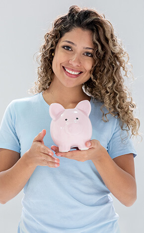 smiling woman holding up a piggy bank